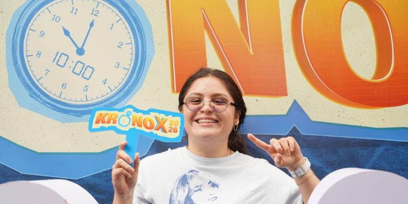 Participante de KRONOX 2026 junto al mural del lanzamiento
